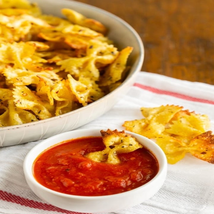 Dipping pasta chips in marinara sauce.